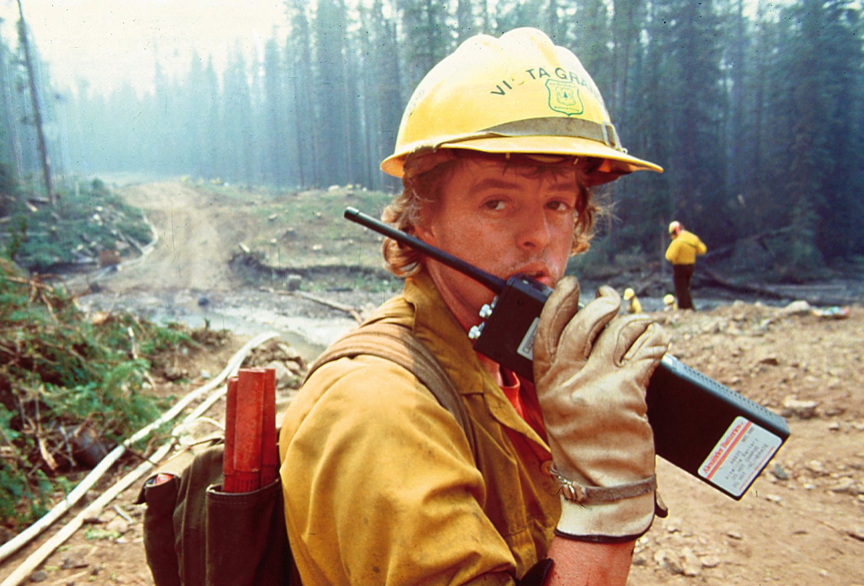 A firefighter helps build a fire break to protect the towns of Cooke City and Silver Gate